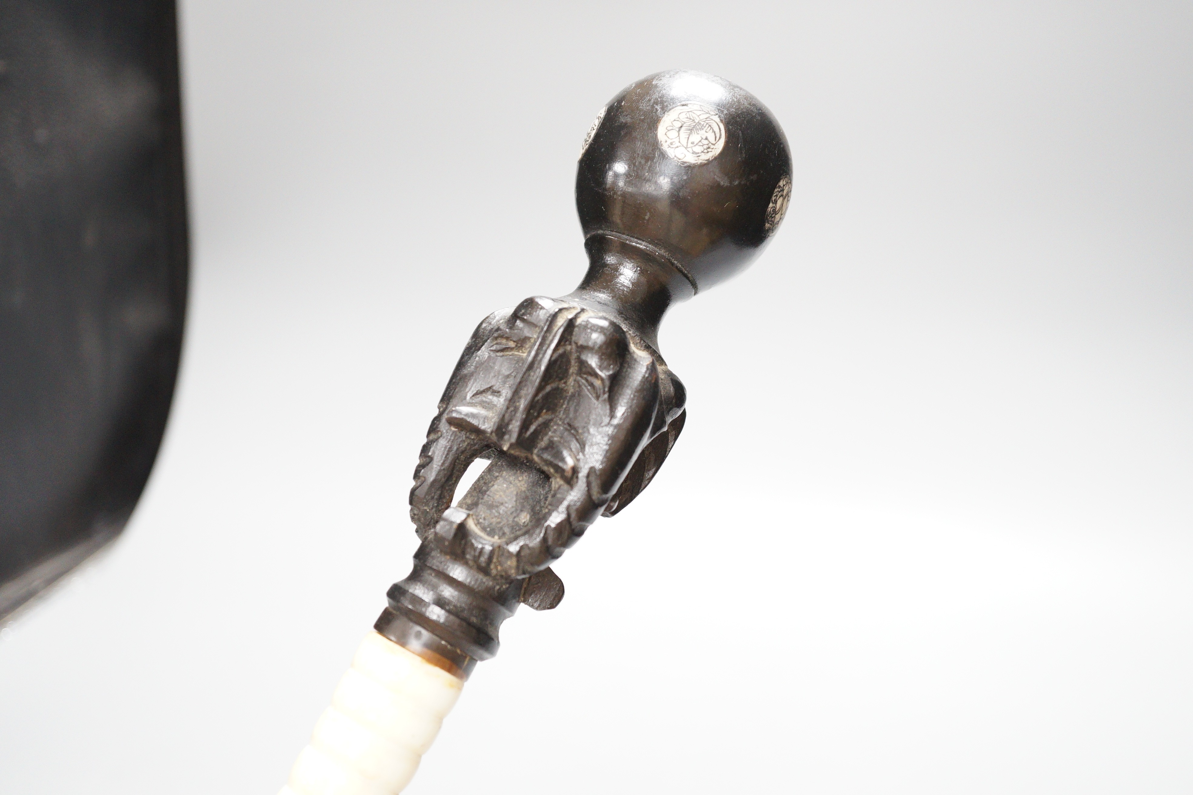 A south East Asian engraved bone and a carved ebony walking cane